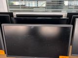 trois écrans d'ordinateur posés sur un bureau devant une fenêtre