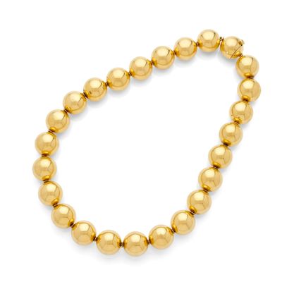 a gold beaded bracelet with a ball clasp