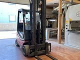 un chariot élévateur dans un entrepôt, avec une machine en arrière-plan
