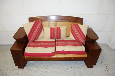 a wooden bench with two pillows on top of it