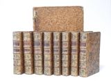several old books are stacked on top of each other on a white surface