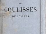 an old book sitting on top of a wooden table next to a window