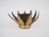a black and gold candle holder on a white surface