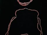 un ensemble composé d'un collier et d'un bracelet en perles roses sur fond noir