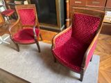 two red chairs sitting next to each other in a room