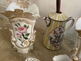 several pieces of porcelain are sitting on the floor next to a vase and teapot
