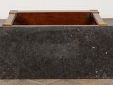 an image of a black marble planter sitting on top of a wooden floor