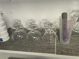 a shelf that has many glasses and cups on it