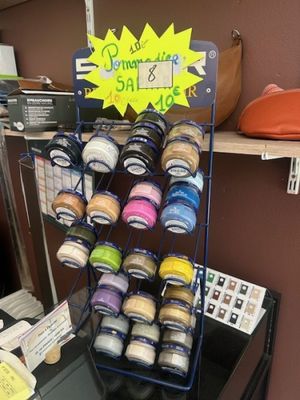une étagère sur laquelle sont disposés des bocaux de différentes couleurs et tailles
