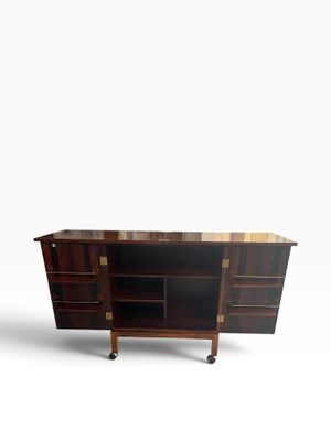 an image of a wooden cabinet with drawers and shelves on casteors