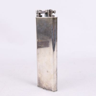 un briquet argenté posé sur une surface blanche
