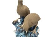 deux figurines d'oiseaux perchés sur un rocher
