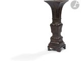 un grand vase en bois posé sur un socle, sur fond blanc
