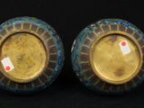pair of blue and gold vases sitting on a black surface