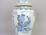 un vase bleu et blanc avec un couvercle posé sur une table