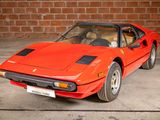 a red sports car parked in front of a brick wall