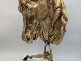 brass horse head sculpture on stand on white background