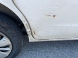 a white car with rust on the side of the road