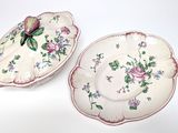 two plates with flowers on them on a white surface