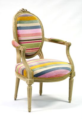une chaise rembourrée dont l'assise est recouverte d'un tissu à rayures multicolores