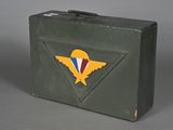 a green suitcase with a red, white, and blue emblem on it