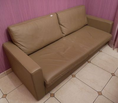 un canapé en cuir marron dans un coin de la pièce