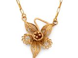 a close up of a gold necklace with a flower on it