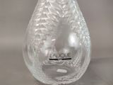 a clear glass vase with a black label on it