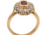 a close up of a gold ring with a ruby and diamond center