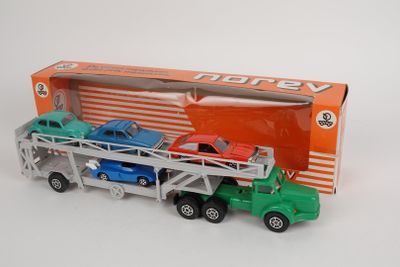 un camion jouet avec des voitures à l'arrière, devant une boîte