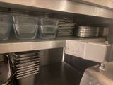 many dishes and pans on the shelf in the kitchen