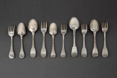 six fourchettes et cuillères alignées en rang sur une table