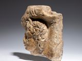 an ancient stone head of a man with a beard on a white surface