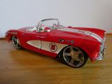 une petite voiture rouge et blanche posée sur une table en bois