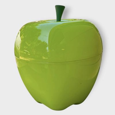 une pomme verte posée sur une surface blanche