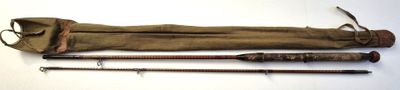 two old fishing rods and a bag on a white surface