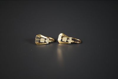 une paire de boucles d'oreilles en or sur une surface noire