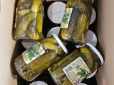 many jars of pickles in a box on the table