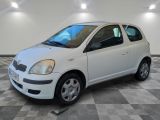a picture of a small white car parked in a garage