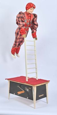 une poupée qui se tient debout sur une échelle suspendue dans les airs