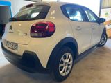 the rear end of a white car parked in a garage