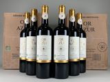 six bottles of red wine sit in front of a cardboard box