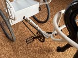 a white chair and a white bicycle in a living room
