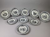 a set of twelve black and white plates with a pattern of flowers and leaves