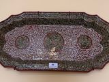a red and black tray on a wall with a tag on it