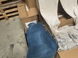 une pile de cartons et un jean par terre