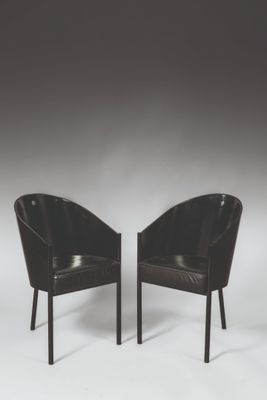 une paire de fauteuils en cuir noir avec des pieds noirs sur fond blanc