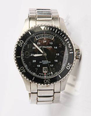 une montre en argent avec un cadran noir sur un fond blanc