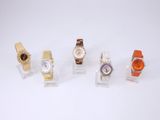 Plusieurs montres différentes sont disposées en rangée sur une surface blanche