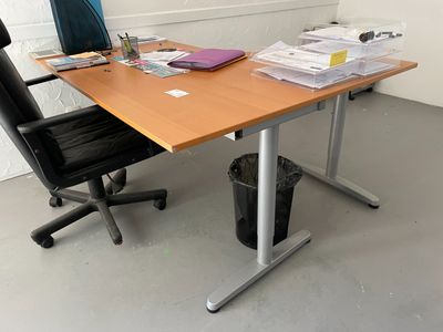 un bureau sur lequel se trouvent une chaise et une poubelle